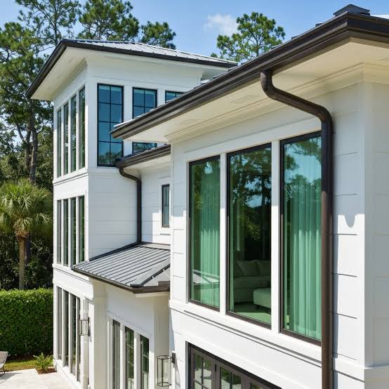 Florida home with dark seamless gutters and downspouts